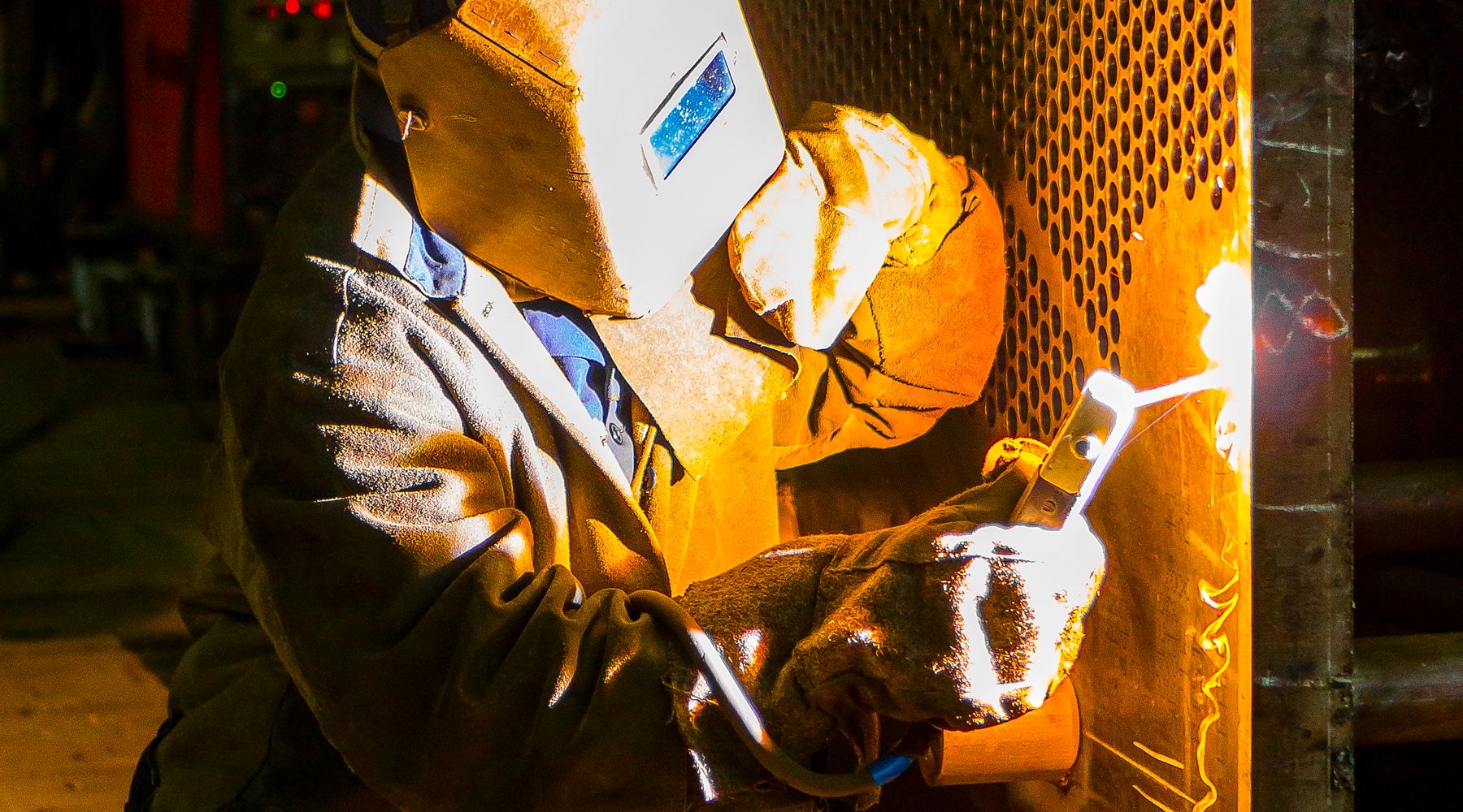 A fabricator welding a mesh stillage panel